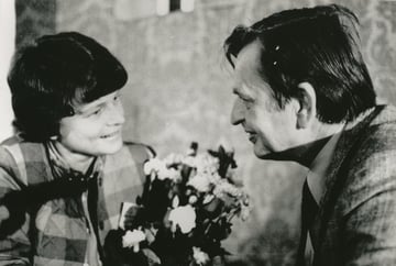nærbilde av Gro Harlem Brundtland og Olof Palme i samtale over blomsterbukett.