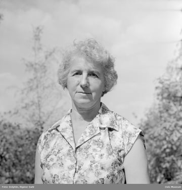 Svart-hvitt bilde av eldre kvinne utendørs