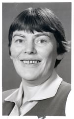 Svart-hvitt portrettfoto av en person med kort hår, sett mot en nøytral bakgrunn.