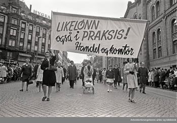 1. mai 1968 i Oslo. Demonstrasjonstoget i Karl Johans gate. Parole: Likelønn også i praksis! Handel og Kontor.
