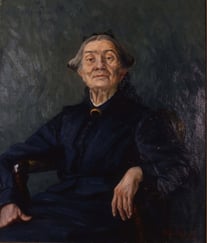 Malt portrett av en eldre kvinne sittende i en stol, kledd i mørke klær mot en mørk bakgrunn.