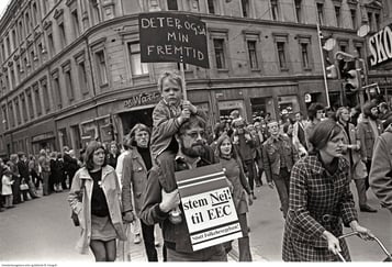 Demonstrasjonstog. Foran i bilde en mann med en gutt på skuldrene. Begge holder plakater med teksten "Stem nei til EEC".