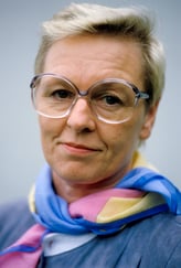 Fargebilde av kvinne med kort hår og briller 