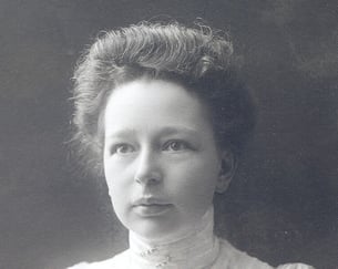 Historisk portrettfotografi av en kvinne med oppsatt hår og høy krage.