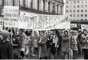 Demonstrasjonstog med plakater og parole med "Det er 15000 lesbiske i Oslo - hvor gjemmer de seg?" og "Kamp mot undertrykking av lesbiske"