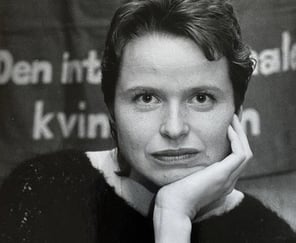 Nærbilde i svart-hvitt bilde av ung kvinne foran en banner