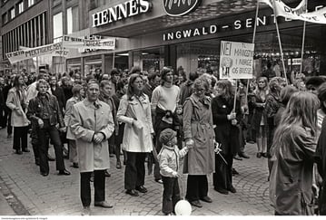 Bilde av et stort antall mennesker i demonstrasjonstog. De holder plakater og paroler.