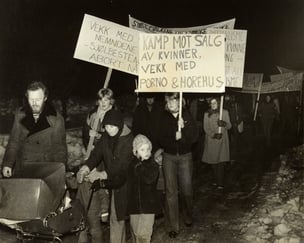 Demonstrasjontog i på snølagt vei. Kvinner, menn og barn. 