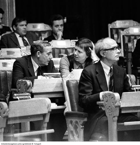 Debatten om familieplanlegging i Stortinget høsten 1974. Torild Skard i samtale med Jo Benkow. Foran sitter Trygve Bratteli, bak skimtes Thorbjørn Berntsen og Lars Roar Langslet.