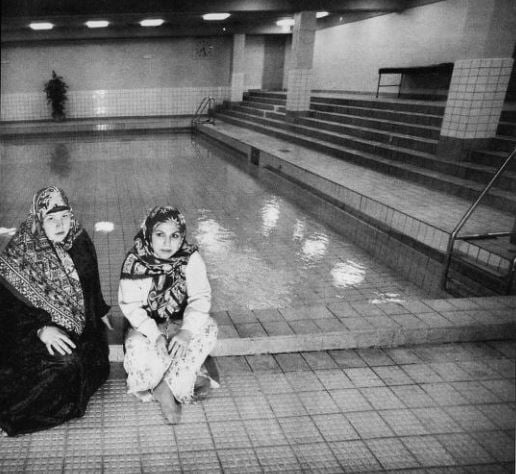 Islamsk Kvinnegruppe organiserte svømmeundervisning for muslimske jenter og kvinner, der menn og gutter over sju år ikke hadde adgang. Her er Sølva Nabila Saxelin og Hajar Yoose Fi foran svømmebassenget i Landåshallen i Bergen. Faksimile fra Bergensavisen 22. mars 1998.