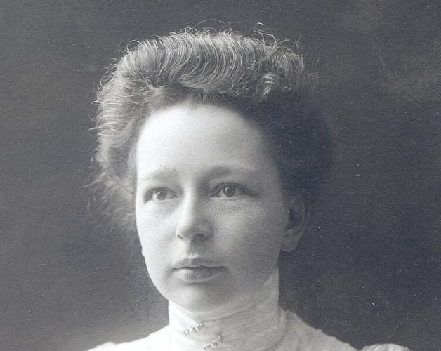 Historisk portrettfotografi av en kvinne med oppsatt hår og høy krage.