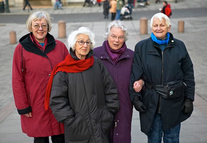 Gruppebilder av fire eldre kvinner med grått hår kledd i ytterjakker og skjerf.
