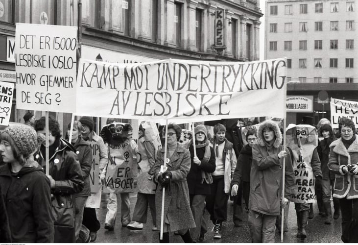 Demonstrasjonstog med plakater og parole med "Det er 15000 lesbiske i Oslo - hvor gjemmer de seg?" og "Kamp mot undertrykking av lesbiske"