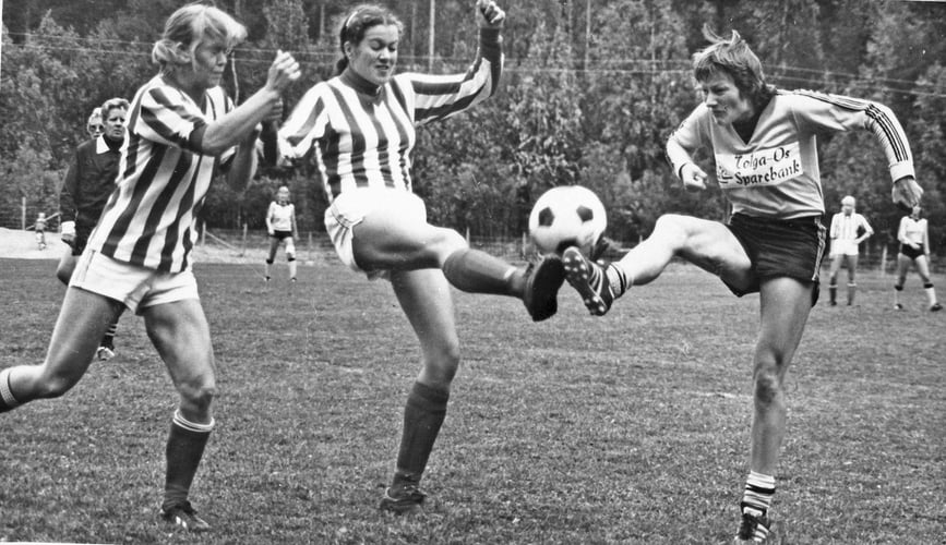 Tre kvinner spel fotball, takling.