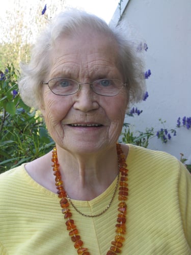 Portrettfoto av eldre kvinne med hvitt hår og briller