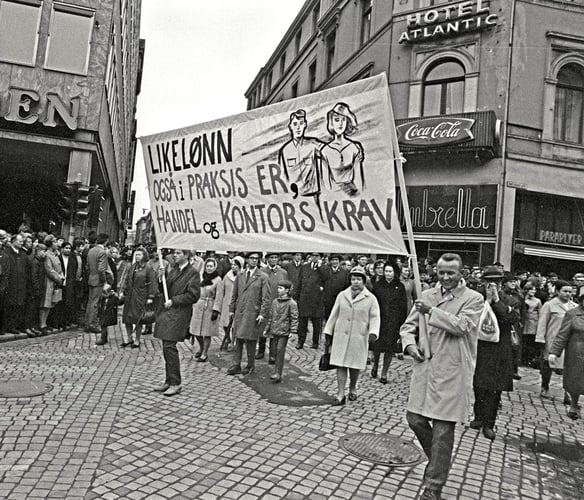 Demonstrasjonstog i bygate med banner som krever «Likelønn også i praksis».