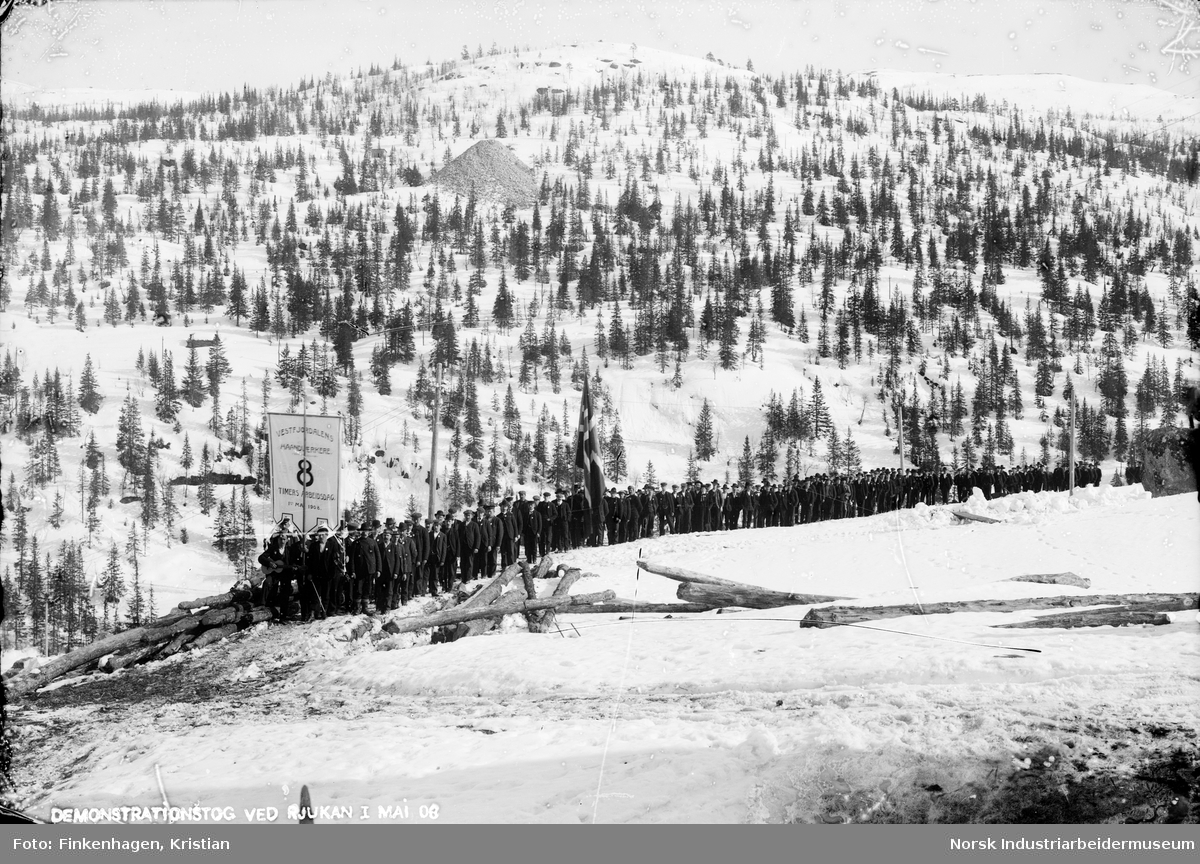 Menn i 1.mai-tog bak parolen til "Vestfjordalens haandverkere". På fanen står kravet 8 timers arbeidsdag 1. mai 1908.