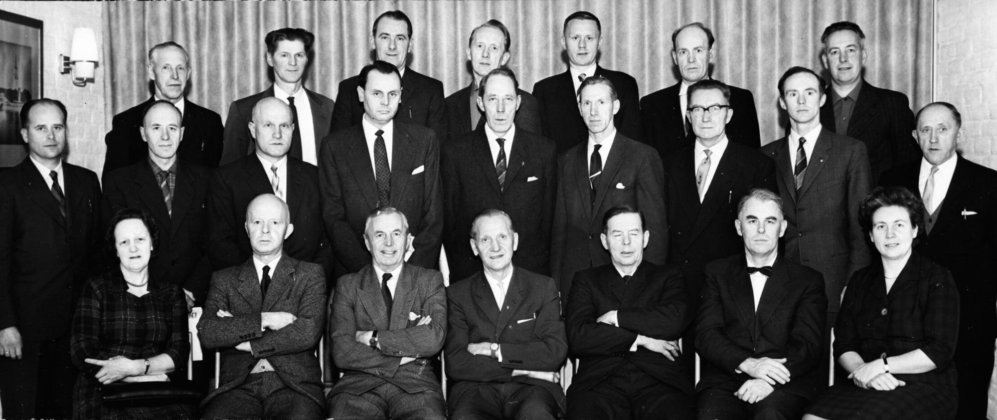Gruppe kommunestyrerepresentanter, to kvinner, mange menn.