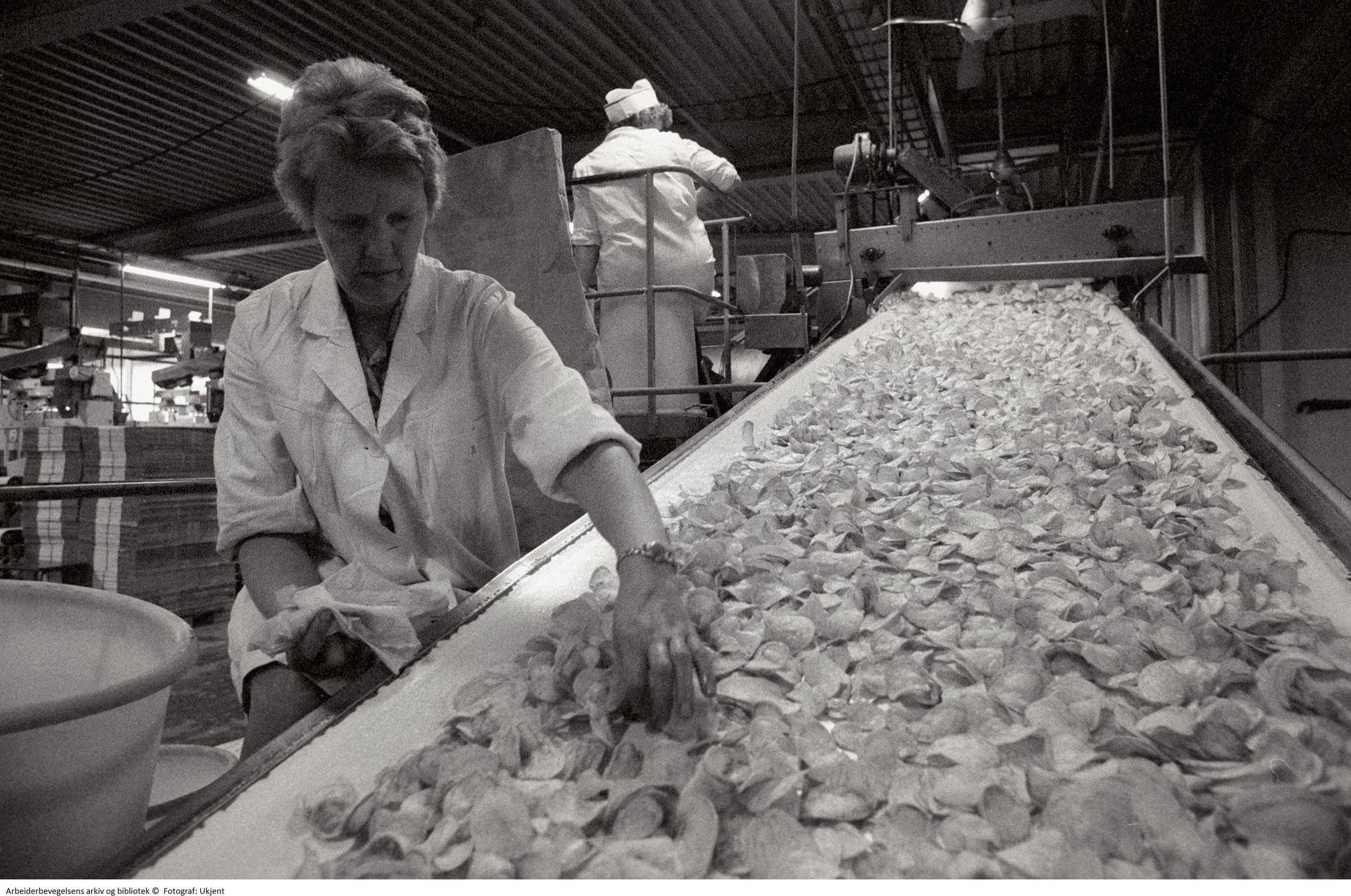 Kvinne i produksjonen på potetgull-fabrikk.