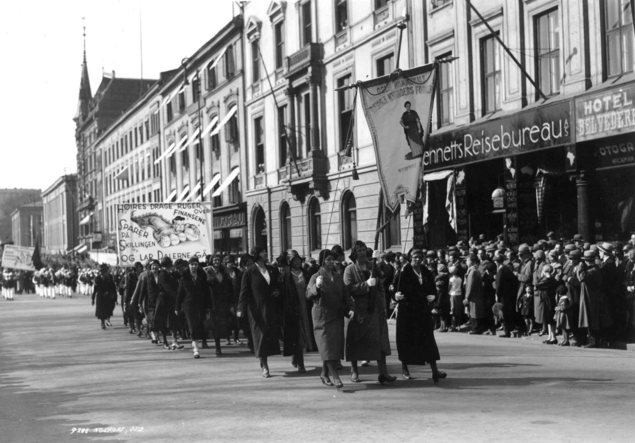 1. mai-demonstrasjon, Karl Johans gate, Oslo, 1930. Oslo kommunale rengjøringskvinner i tog. Faner og paroler. Tilskuere.