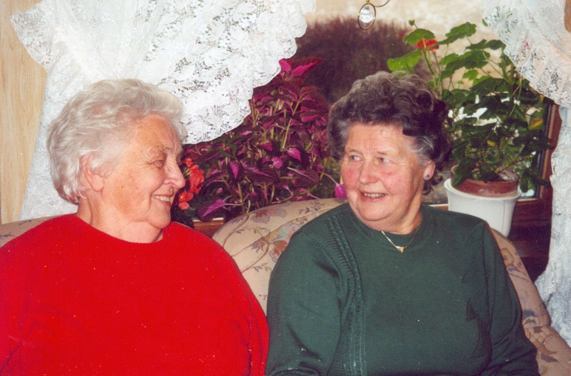 To eldre kvinner snakker med hverandre i sofakroken.
