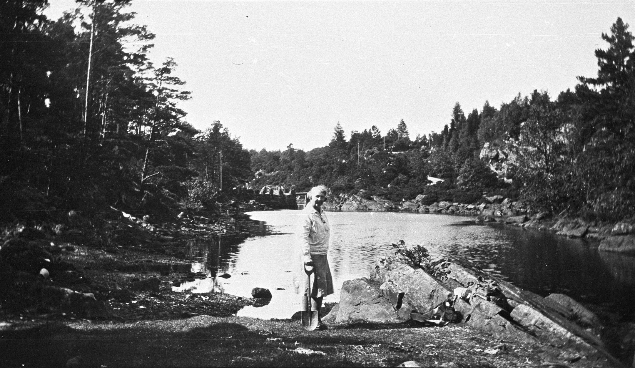Bilde av kvinne fotografert utendørs ved et vann.