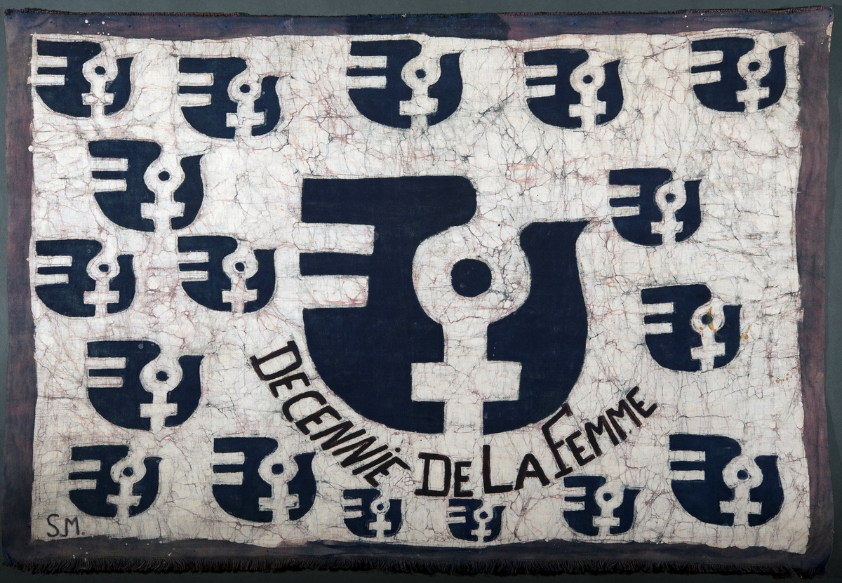 Veggteppe i svart og hvit med feministsymbol.