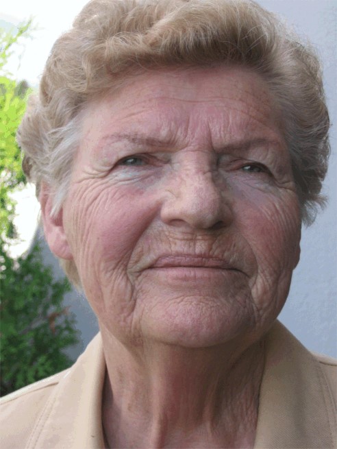 Portrett av kvinne med kort h&aring;r som ser inn i kamera