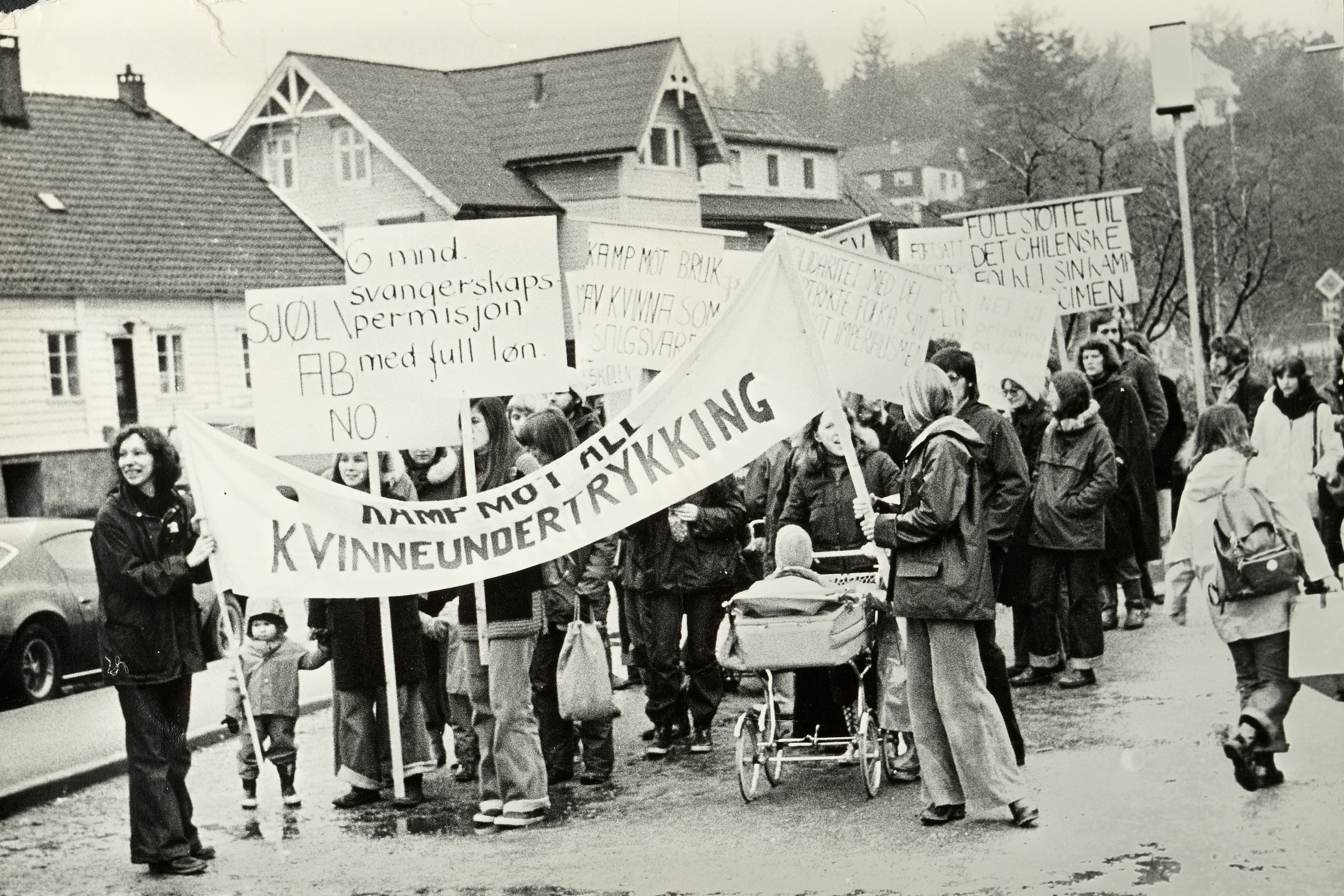 Demonstrasjonstog, kvinner, menn barn og barnevogn. 